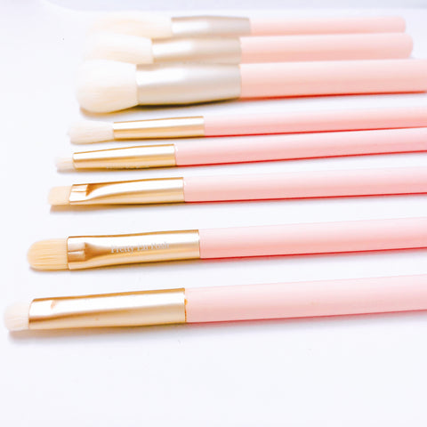 Makeup brush set with white bristles, gold accents and pink handle.