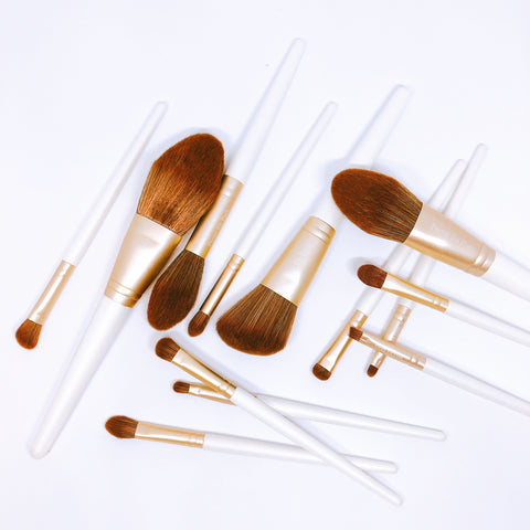 Makeup brush set with brown bristles, gold accents and white handle.