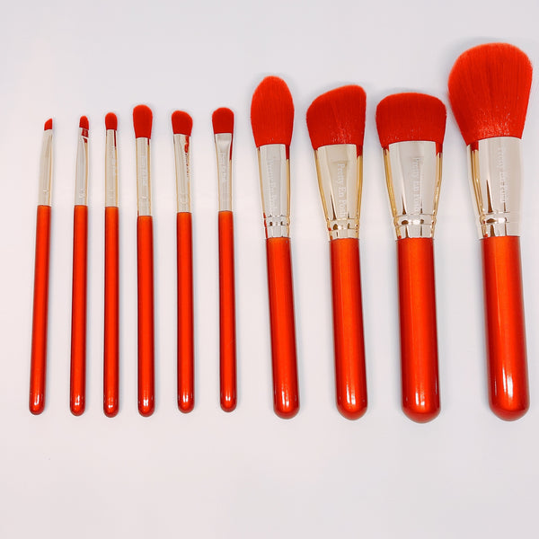 Makeup brush set with red bristols and handle.