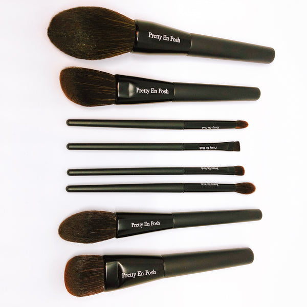 Makeup brush set with brown bristles and a black handle.
