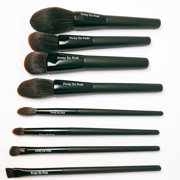 Makeup brush set with brown bristles and a black handle.