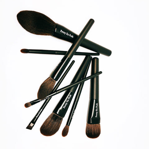 Makeup brush set with brown bristles and a black handle.